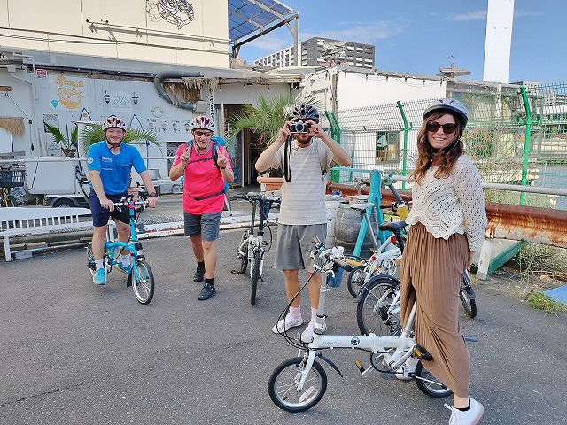 Four guests on a bike tour of Tokyo, wearing helmets and sunglasses.