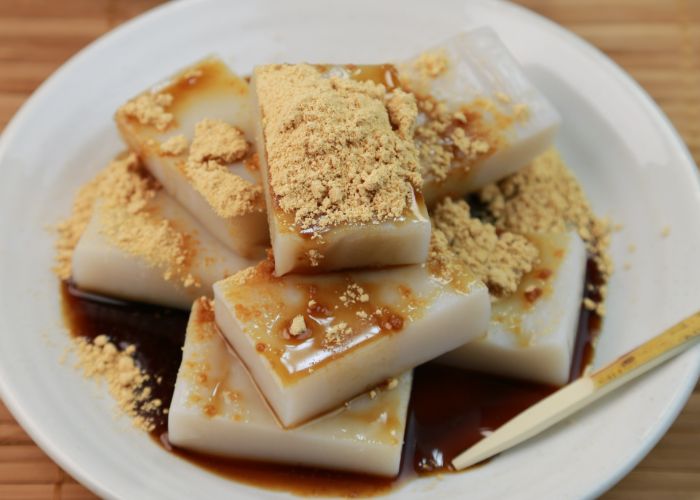 Pieces of kuzumochi served with brown sugar syrup and kinako powder