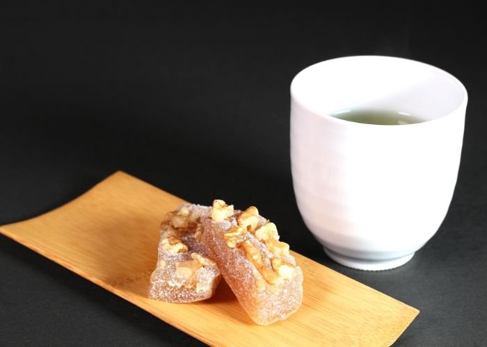 Two pieces of yubeshi (a traditional Yuzu-flavored Nara confectionary) served with a cup of Japanese green tea