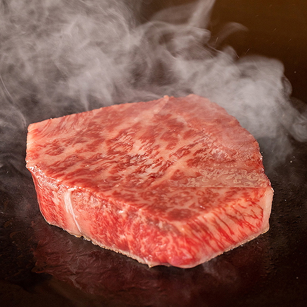 Juicy Wagyu steak sizzling on grill with steam rising
