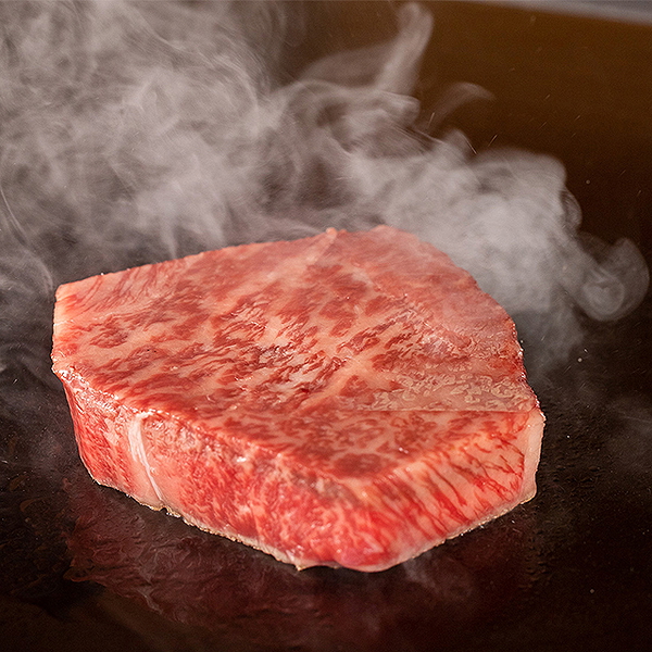 Sizzling Wagyu beef on a hot grill with steam
