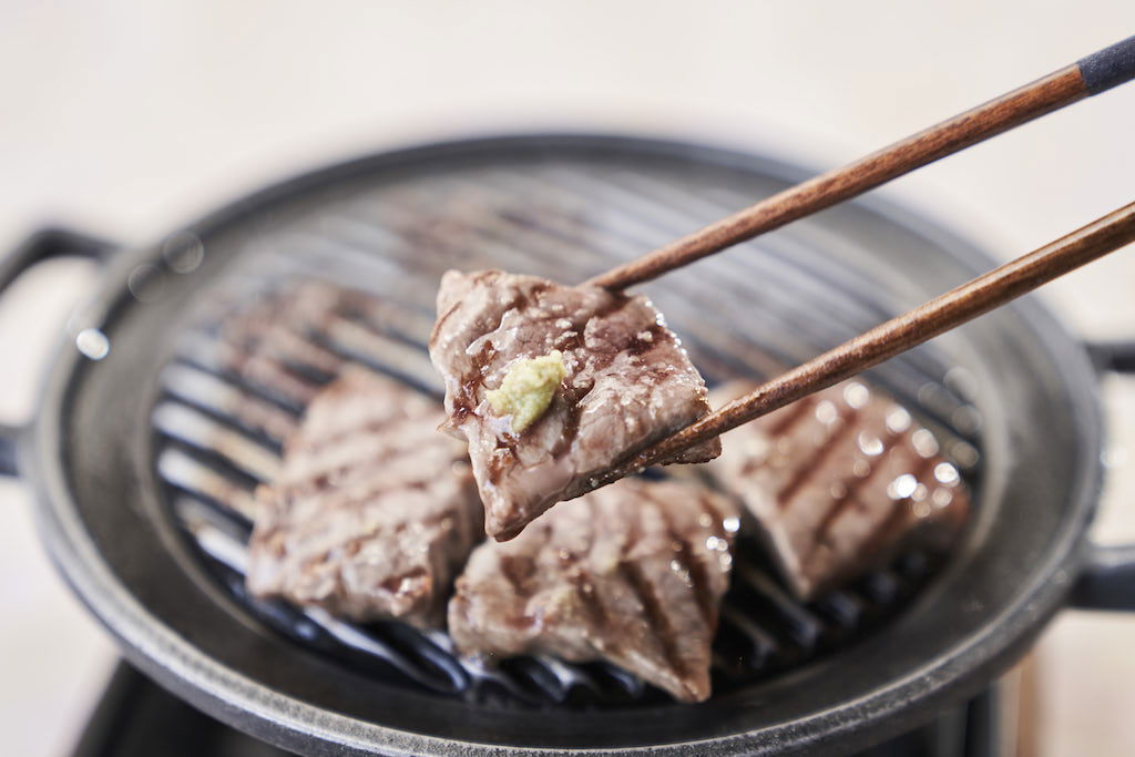 Small slices of wagyu beef grilled; they have grilling lines across them.