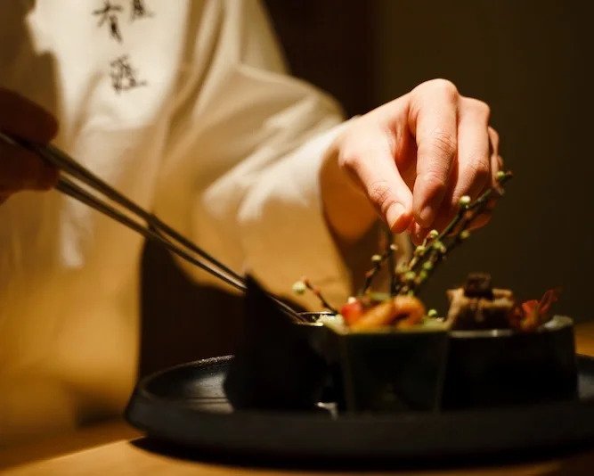 Chef Ryogo Fujii preparing a dish at his restaurant, Ginza Ugai