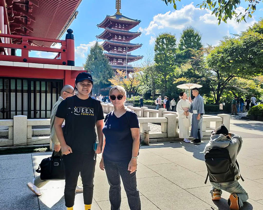 Two guests of this Asakusa tour, smiling with the iconic 5-story pagoda of Senso-ji Temple in the background.