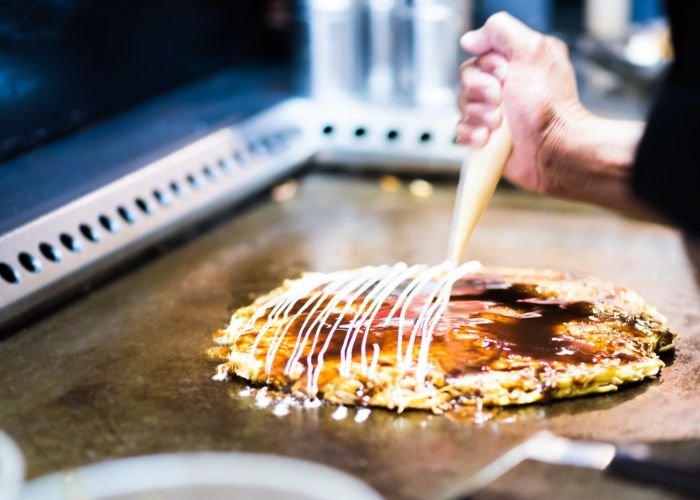 Osaka-style okonomiyaki on a grill
