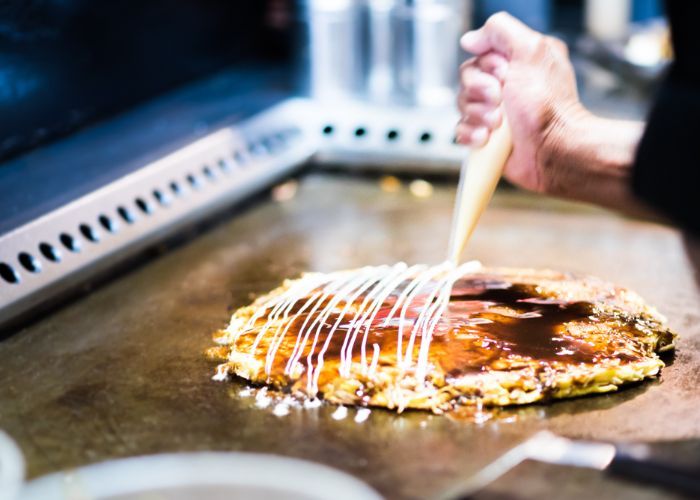 Osaka-style okonomiyaki on a grill