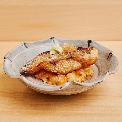 Gourmet fish dish with risotto served on a rustic ceramic plate