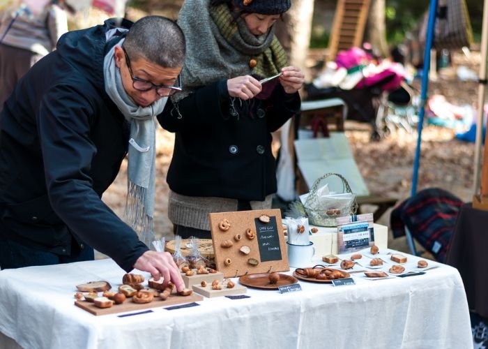 A man sells bread-shaped brooches at a flea market in Kyoto