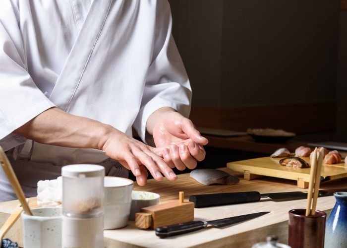A chef is preparing sushi at an omakase restaurant in Japan