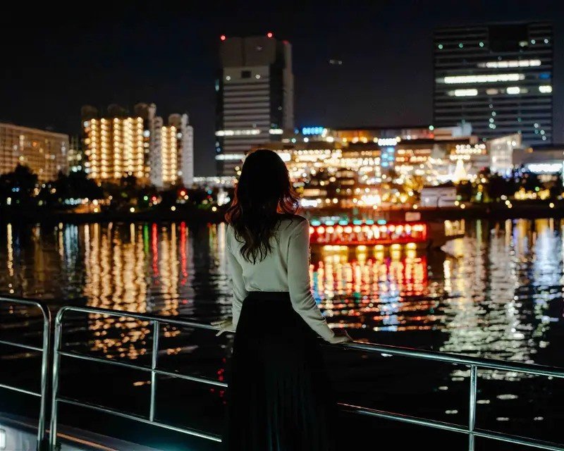 A woman overlooking Tokyo Bay aboard a private boat