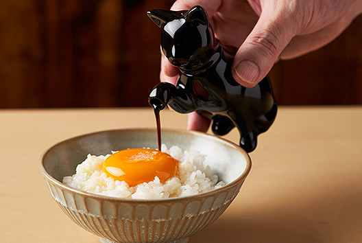 Soy sauce poured over egg-topped rice bowl