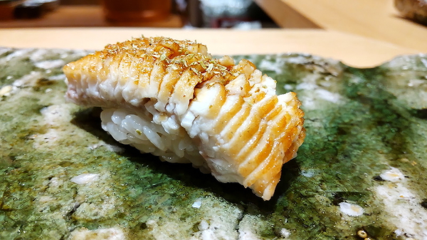 Sushi nigiri topped with grilled unagi on ceramic plate