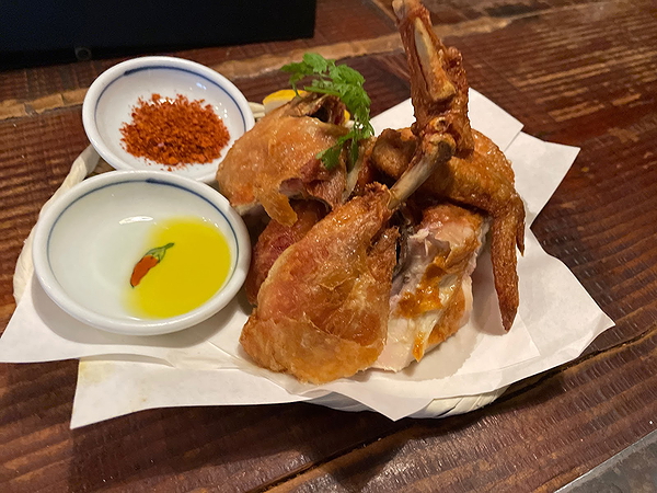 Crispy fried chicken served with dipping sauce at a rustic restaurant