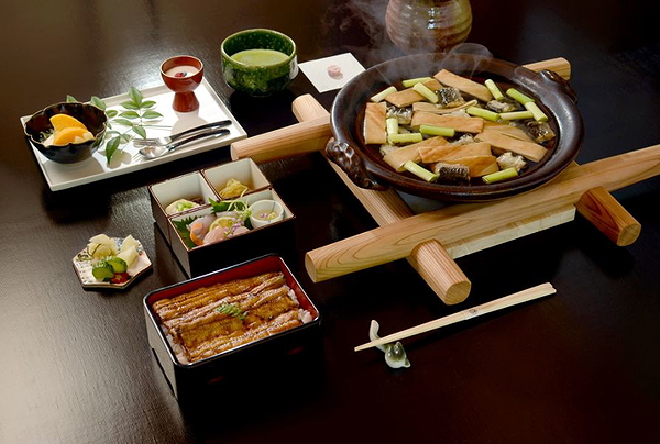 Traditional Japanese meal with savory dishes on a dark wooden table