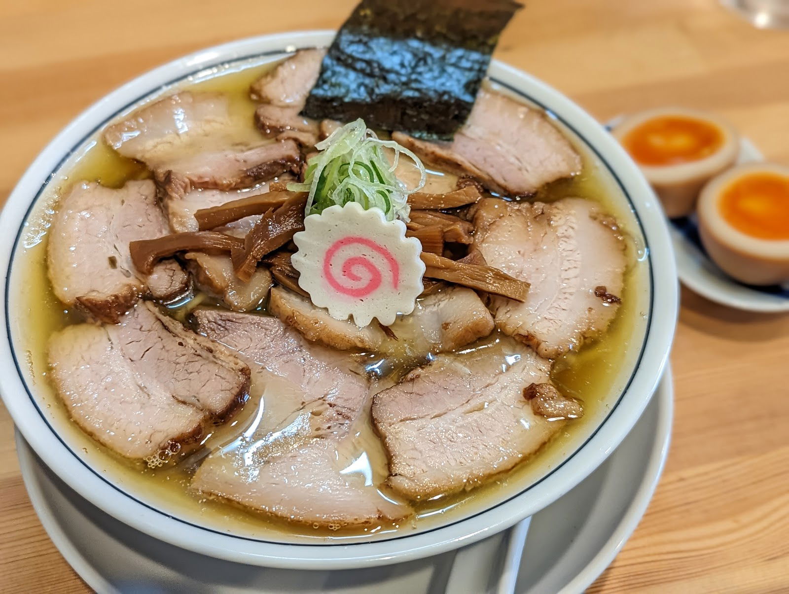 A bowl of pork-packed ramen at there is ramen, featuring a naruto fishcake in the center.