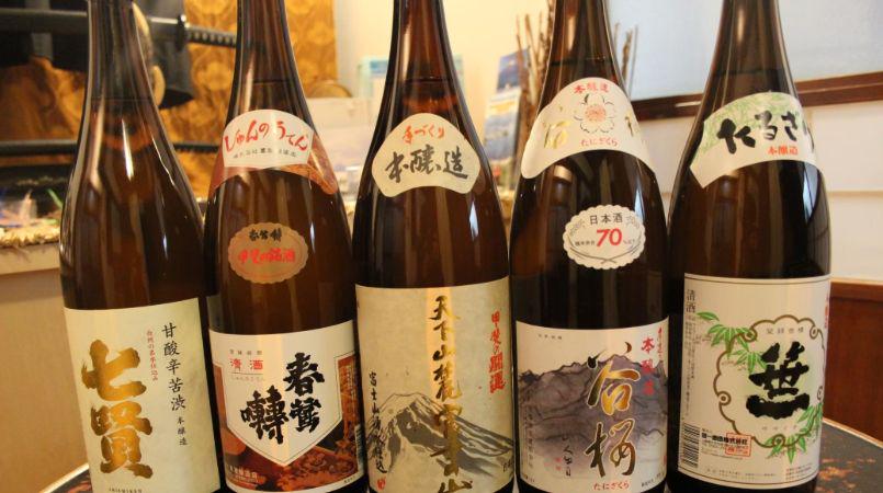Five bottles of Nihonshu, Japanese sake, lined up and ready for drinking.