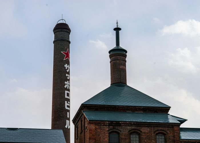 Sapporo Beer Brewery, with the logo and brand name printed vertically along the brewery's chimney.