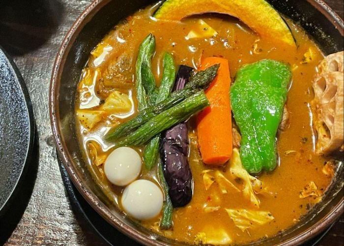 A top-down shot of Ramai Sapporo's soup curry, served with a range of colorful vegetables.