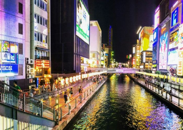Osaka's famous Dotonbori at night, with the lights of the nearby signs reflecting on the river.