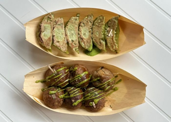 Six matcha gyoza and six matcha takoyaki, each lined up in thin bamboo trays.