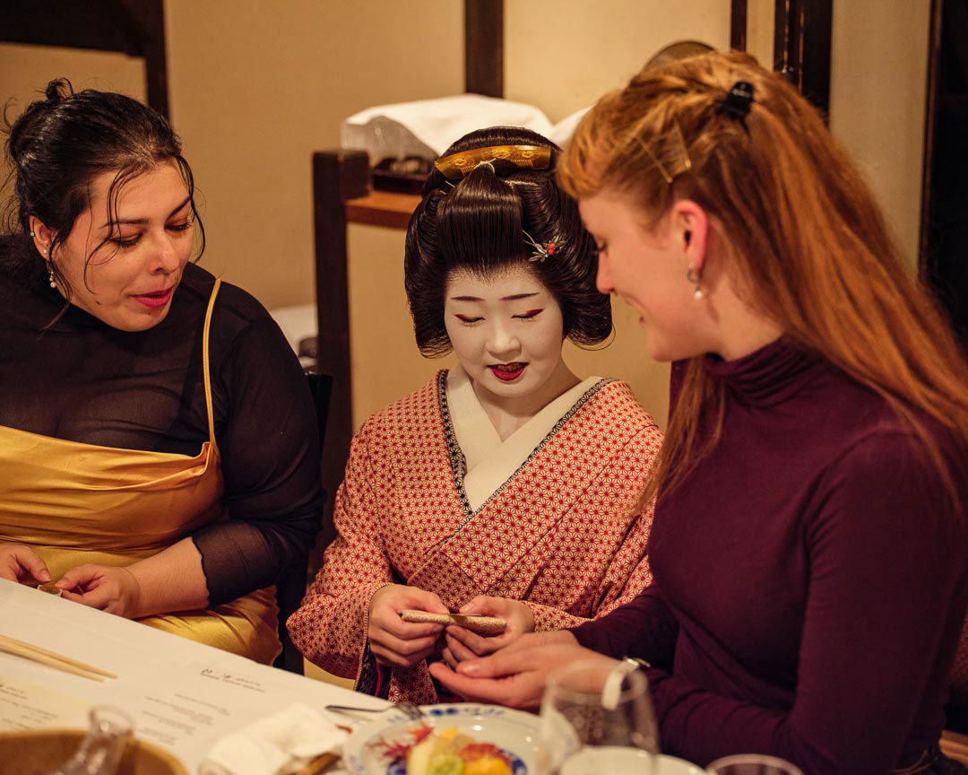 In this geisha performance and private dinner in Sapporo, Hokkaido, two guests are chatting to a demure geisha in the center.