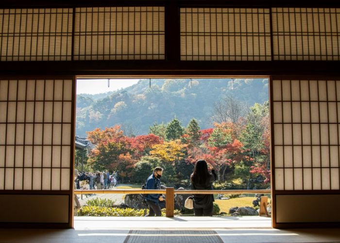 Looking out of Tenryuji Temple Shigetsu, where tourists are taking photos of the Fall leaves.