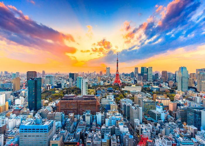 Overlooking the city of Tokyo as the sun sets, with the Tokyo Tower near the center of the shot.