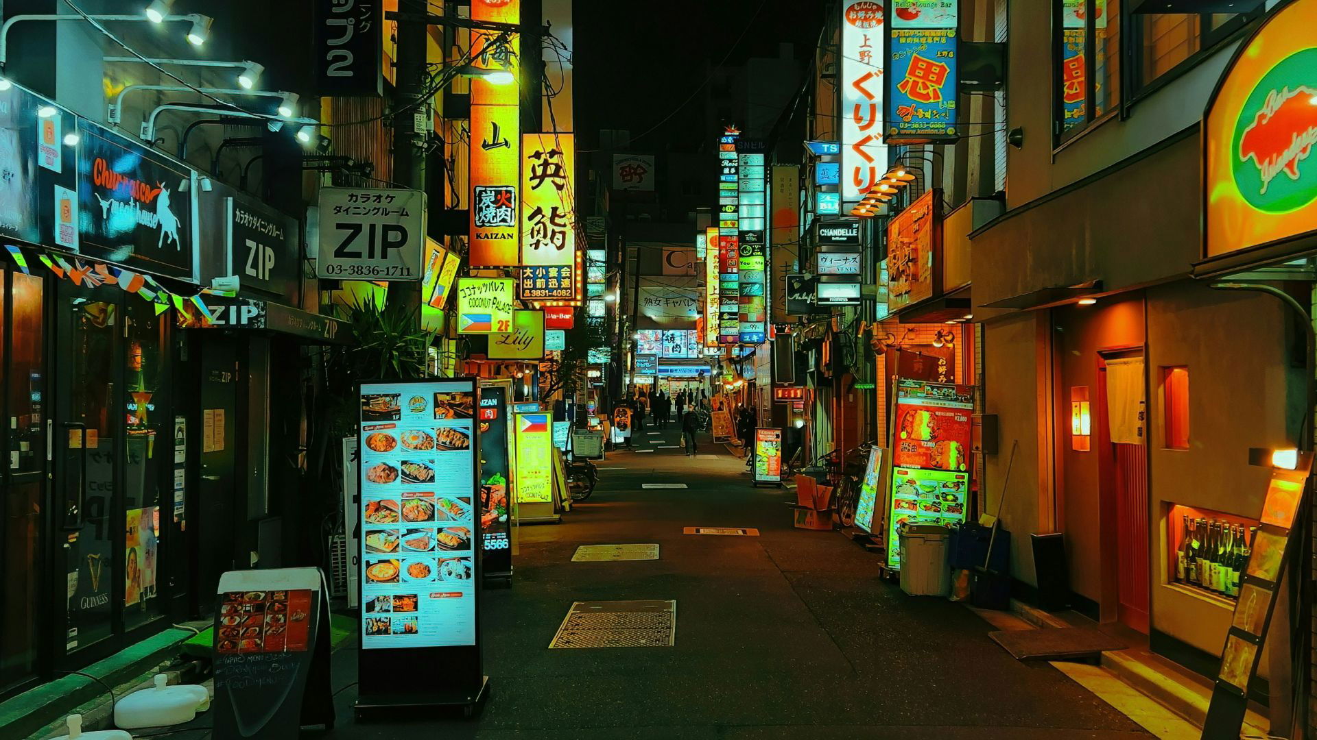 Neon-lit street in Tokyo with vibrant signs and restaurant menus
