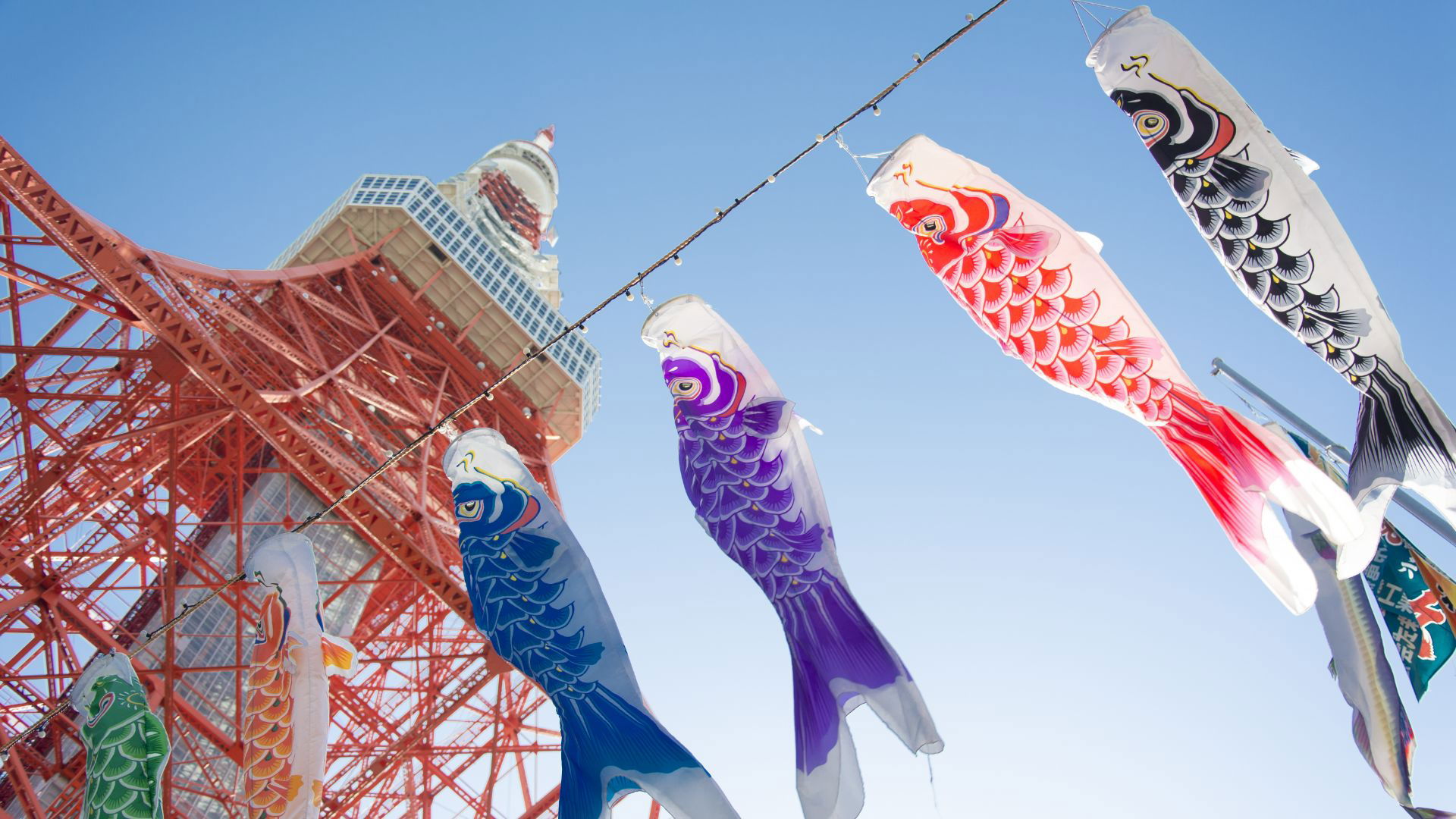 Colorful koinobori streamers near Tokyo Tower in clear blue sky