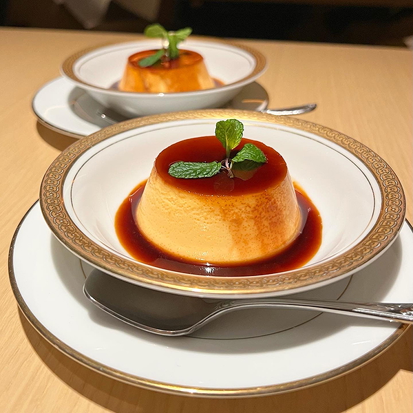 Elegant caramel flans with mint garnish in a fine dining restaurant