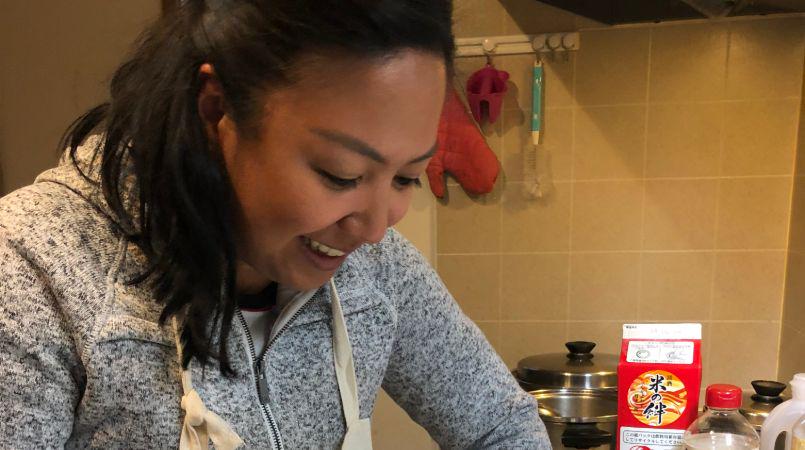 A smiling guest cooking at this Ninomiya cooking class.