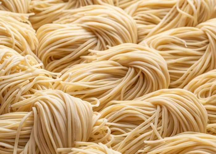 A close-up shot of fresh ramen noodles, twisted together.