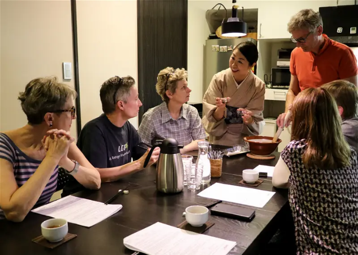 A lady explains the art of authentic sushi to a table of tourists.