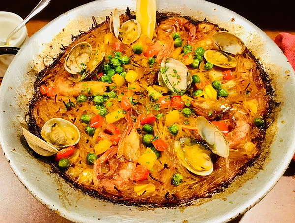 Delicious seafood paella garnished with colorful vegetables