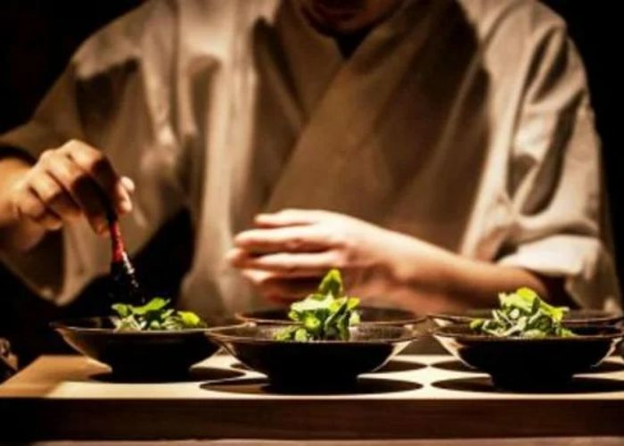 A chef at Yakitori Ichimatsu, making the final touches to dishes that are waiting to be served.