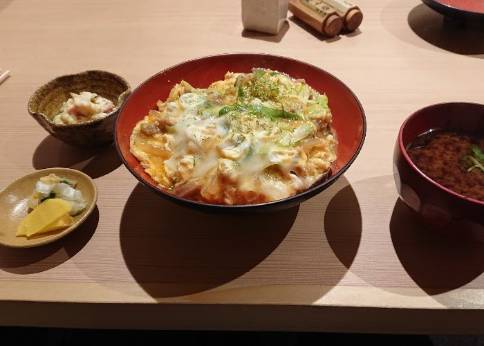 A fresh bowl of oden in the center, surrounded by tsukemono, a side dish, and miso soup.