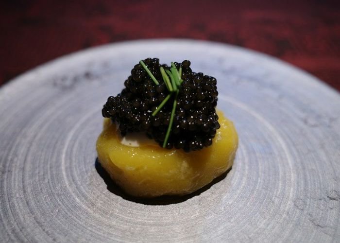 A delicate serving of Michelin star Italian food in Osaka. It appears to be caviar and chives.