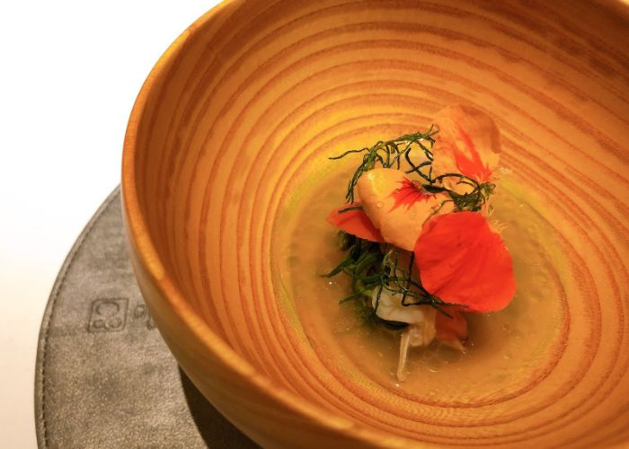 French food, delicately served in a ringed wooden bowl, appearing almost like a butterfly.