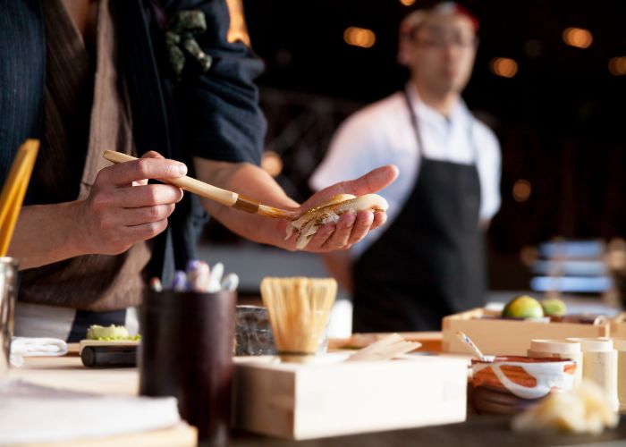 A chef prepares food or customers in a restaurant in Japan.