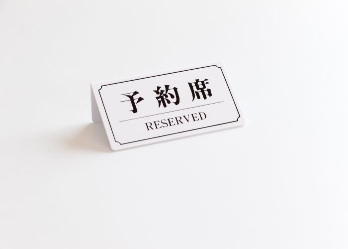 A plaque that marks that a table is reserved in Japanese and English.