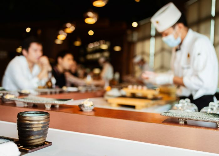 A chef is working behind the counter at a high end restaurant in Japan