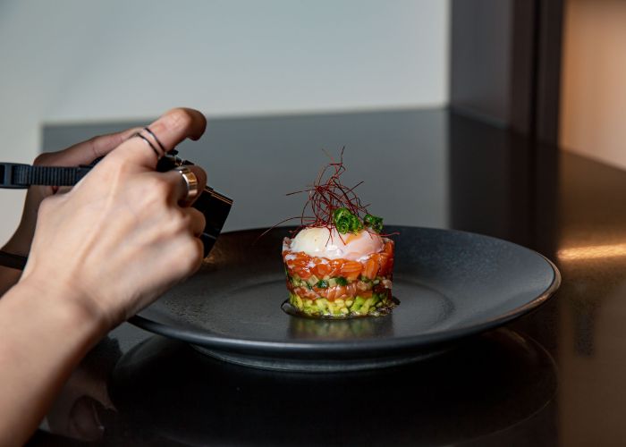 A diner takes a photo of a dish at a restaurant in Japan.