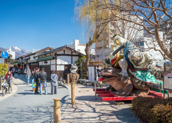 The entrance to Nawate Shopping Street with a statue of two samurai frogs