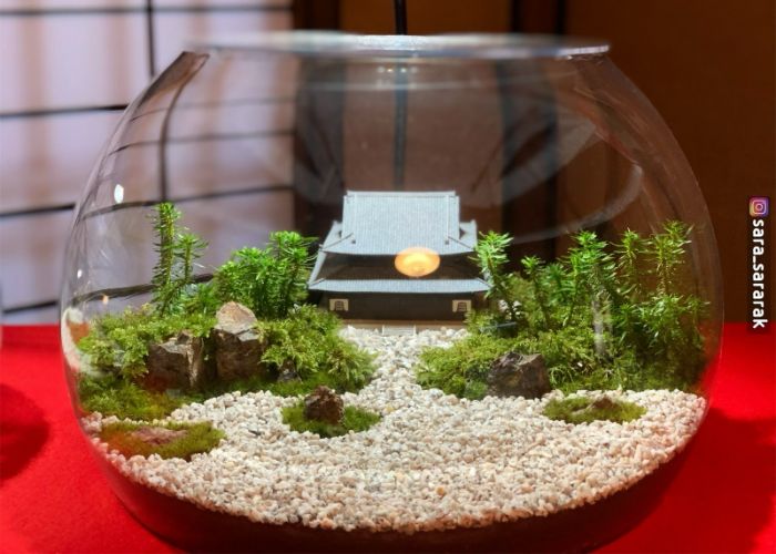 A table decoration at Maeda, a Michelin star restaurant in Kyoto. It looks like a Japanese temple and Zen rock garden inside a fishbowl.