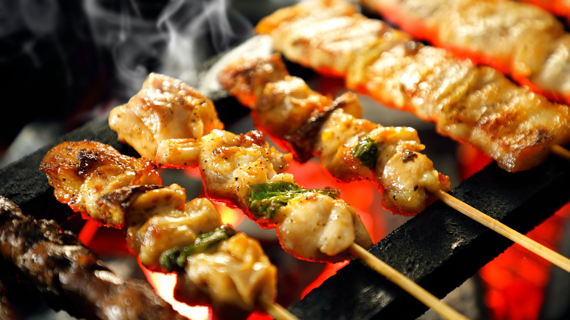 Grilled chicken skewers sizzling over hot coals