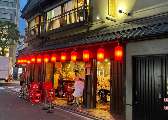 A shot from the street, looking across at Iseya, an inviting yakitori restaurant in Tokyo lit by the traditional red lanterns of izakaya.