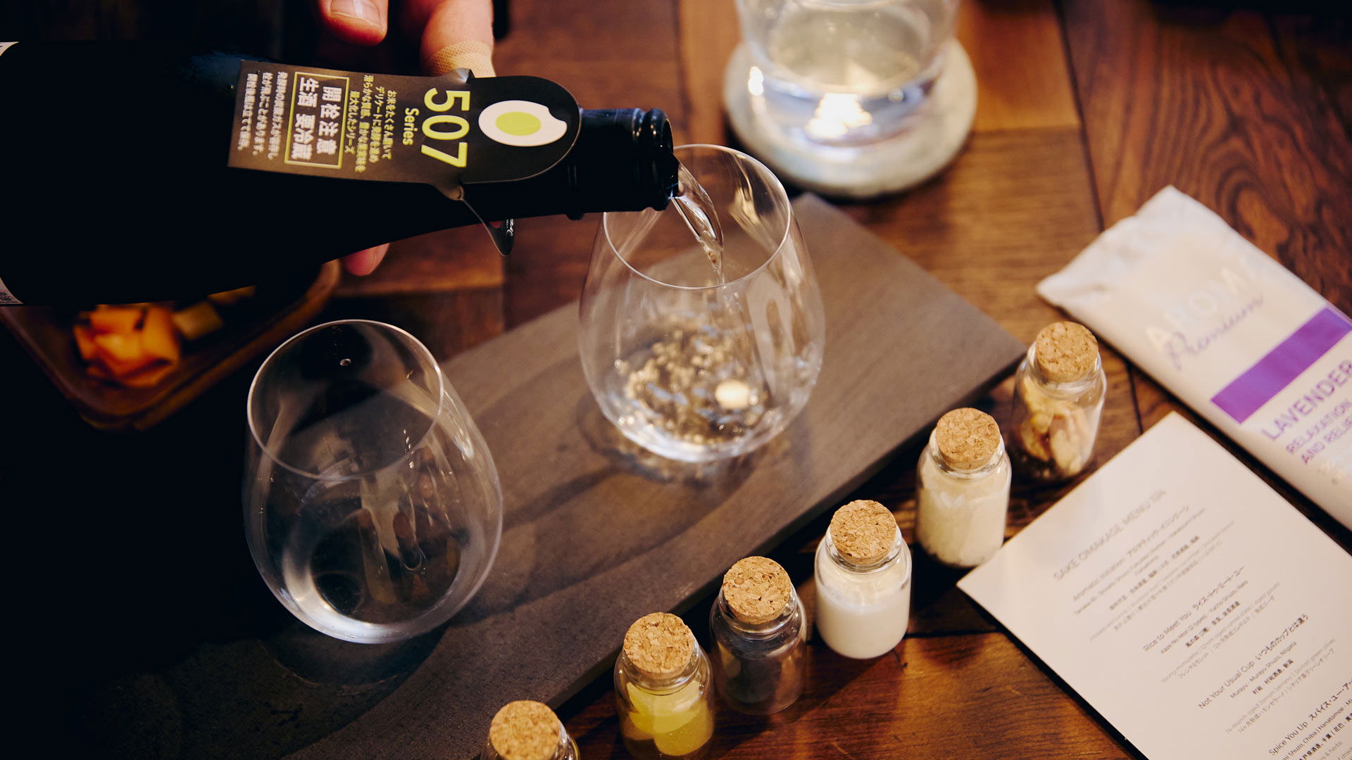 A bottle of sake is being poured into a waiting glass.