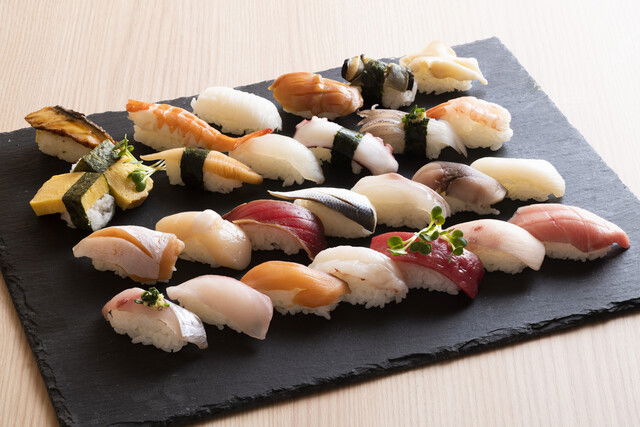 Rows of many different types of sushi on a plate