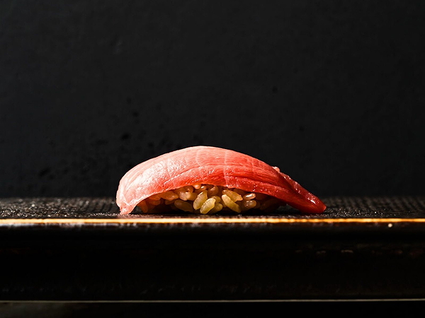Close-up view of fresh tuna nigiri sushi on dark background