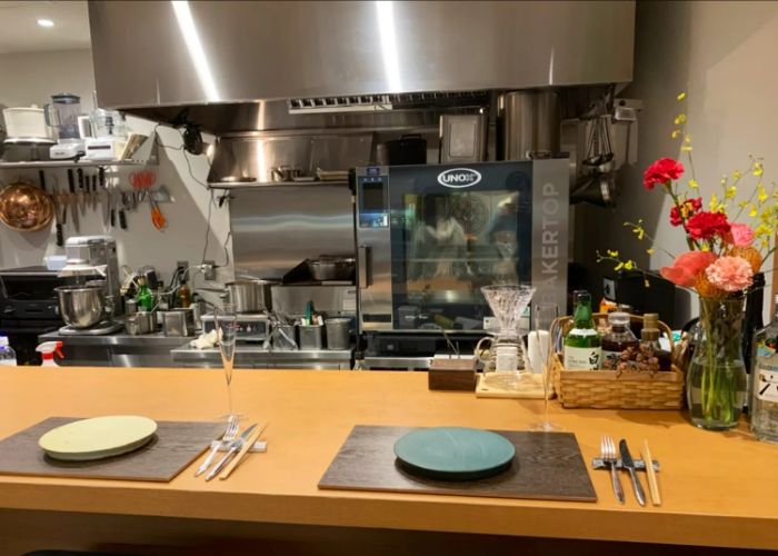 The interior of Roku, a Michelin star cafe in Tokyo. Two plates are waiting for guests at the counter.